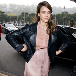 Actress Jessica Alba tones down the girliness of a pale pink dress with a black leather jacket.